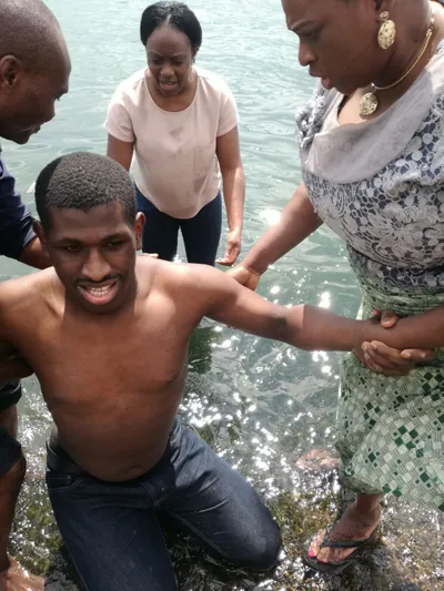 Baptism by immersion of a man by a man and two woman