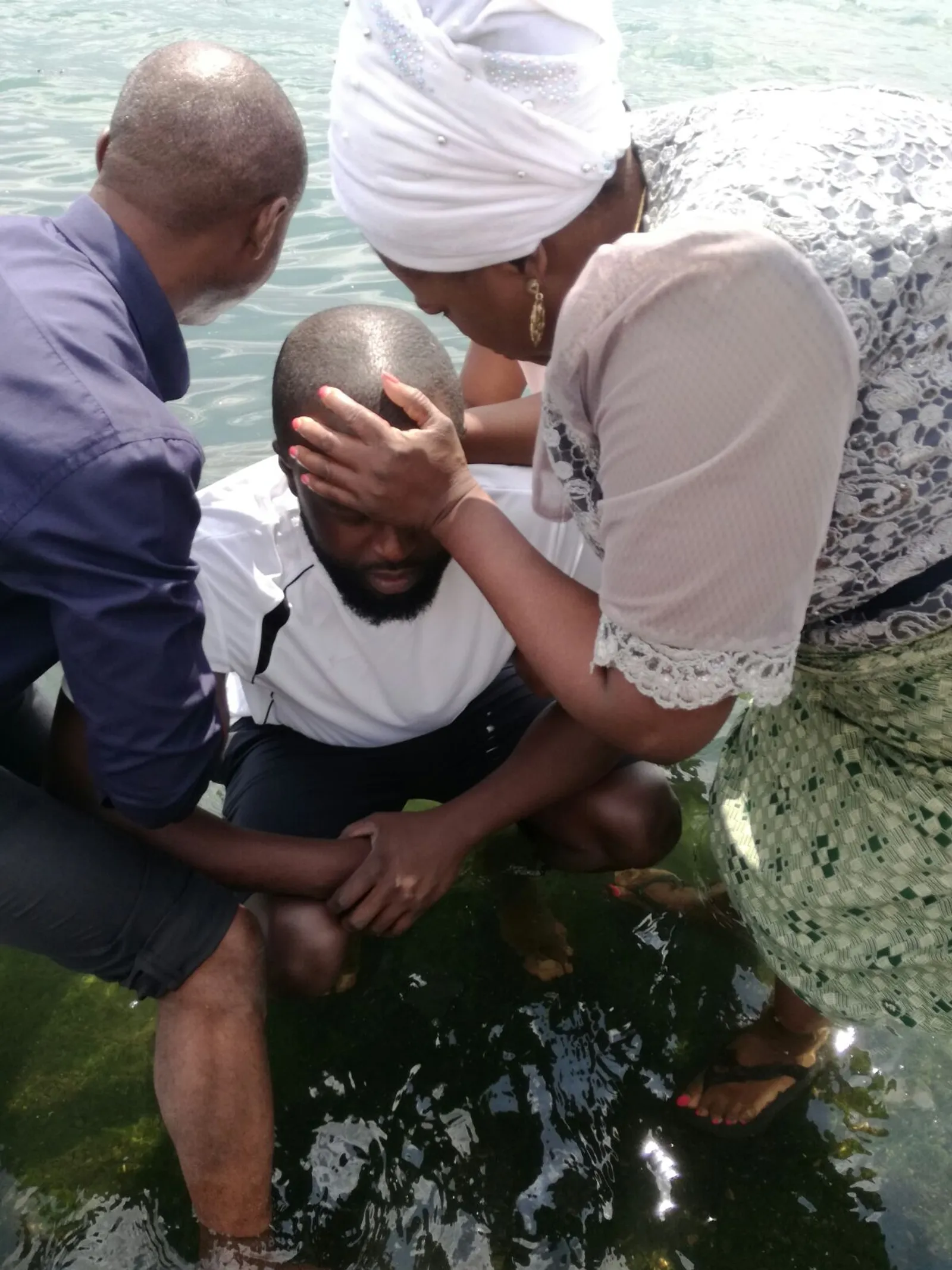 Baptism by immersion of a man by a man and a woman
