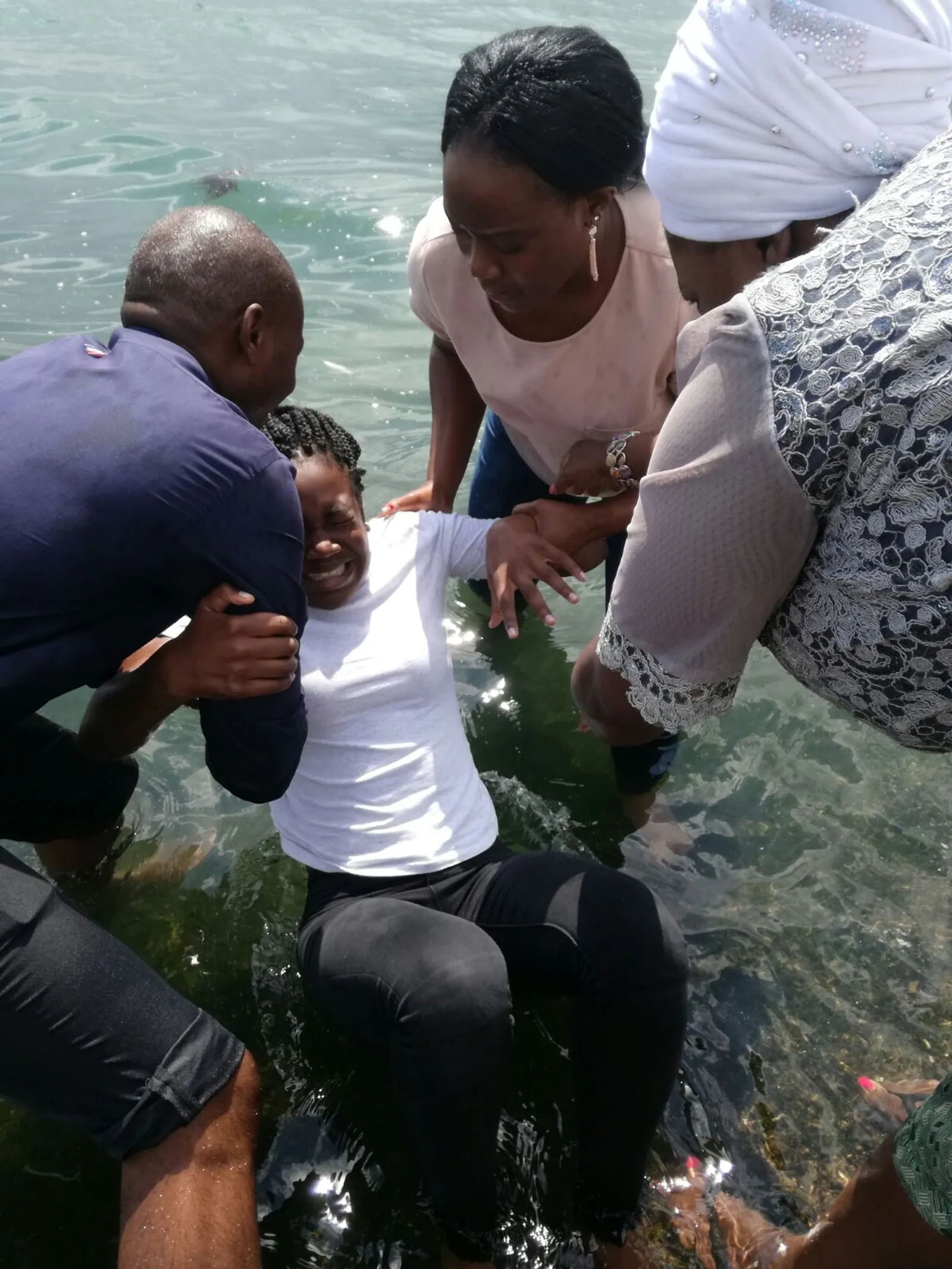 Baptism by immersion of a woman by a man and a woman